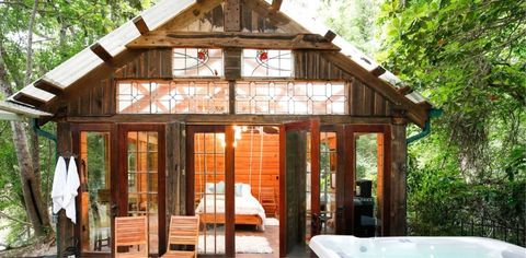 This Cedar Cabin in Texas Has Beautiful Stained-glass Windows, A Swinging Bed, And A Hot Tub In The Middle Of The Woods