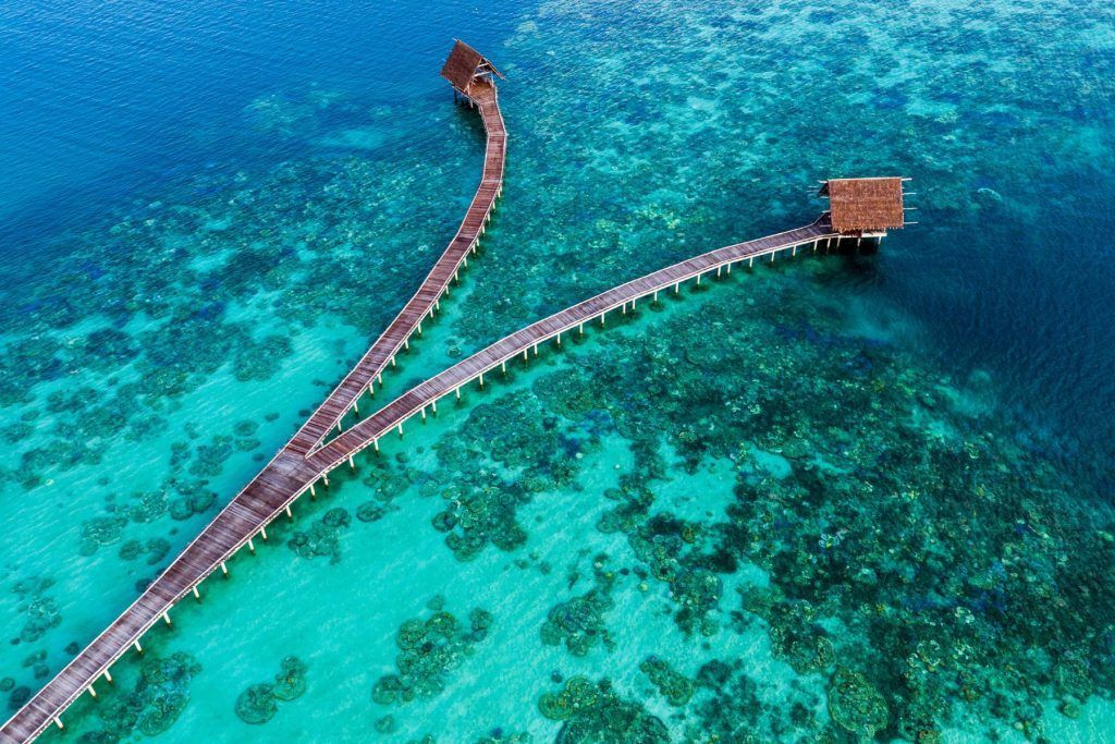 Wooden jetty with thatched roof in coral reefs lagoon